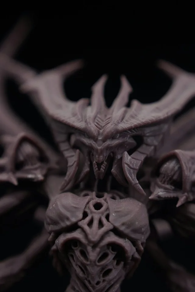 A detailed, dark sculpture of a demonic creature.
